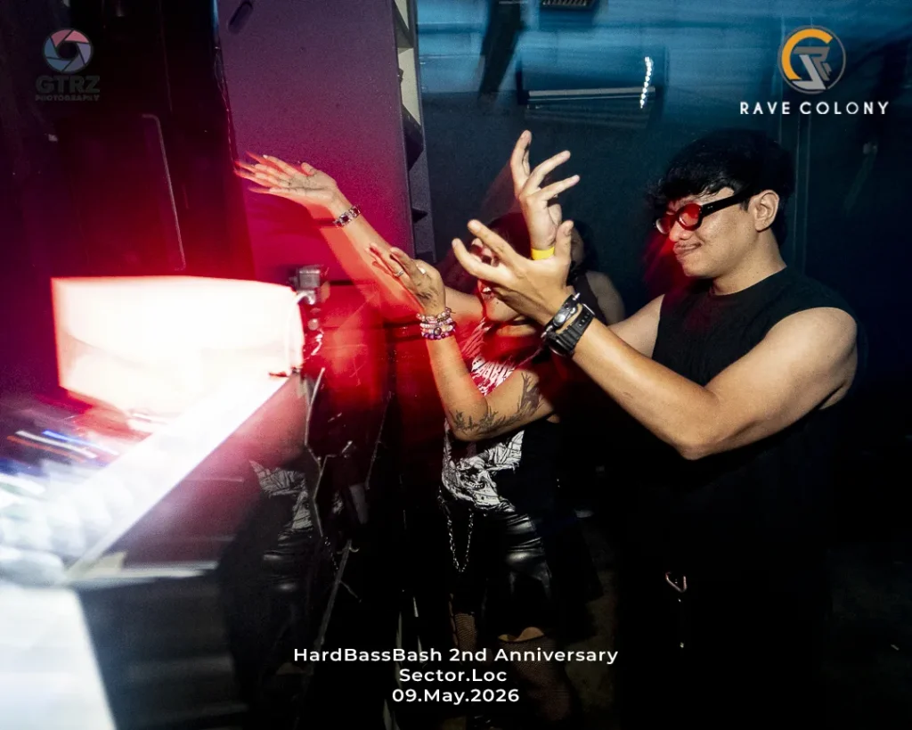 People at a club DJ booth raising hands in excitement; event text at bottom reads 'HardBass Bash 2nd Anniversary Sector.Loc 09.May.2026' with logos in corners.
