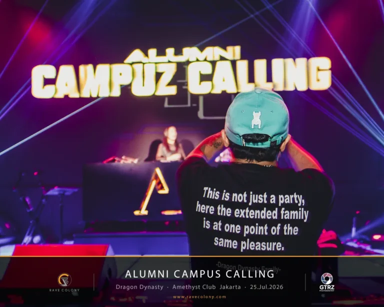 Back view of a person wearing a teal cap filming a stage during an 'Alumni Campus Calling' event with a DJ booth and neon sign in the background, shirt text visible: 'This is not just a party...'.