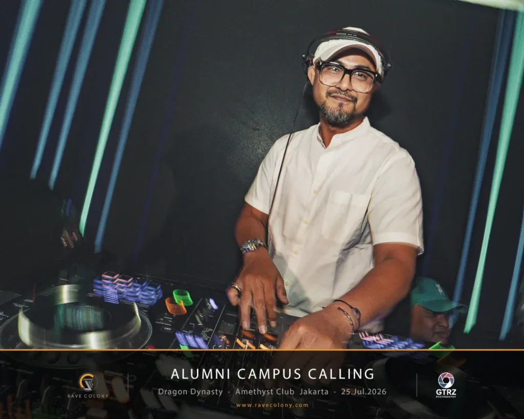 DJ wearing a white shirt and glasses, with headphones, mixes music at an Alumni Campus Calling event in Jakarta