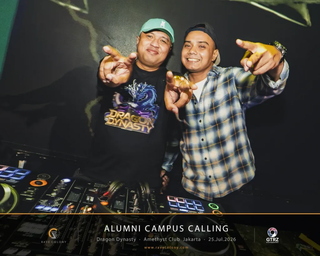 Two men DJing at a booth, pointing and smiling during Alumni Campus Calling event.