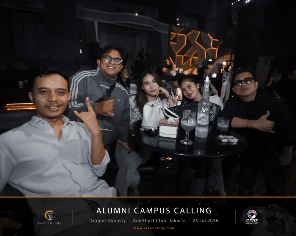 Group of five friends posing at a dim club table with drinks during an Alumni Campus Calling event in Jakarta.